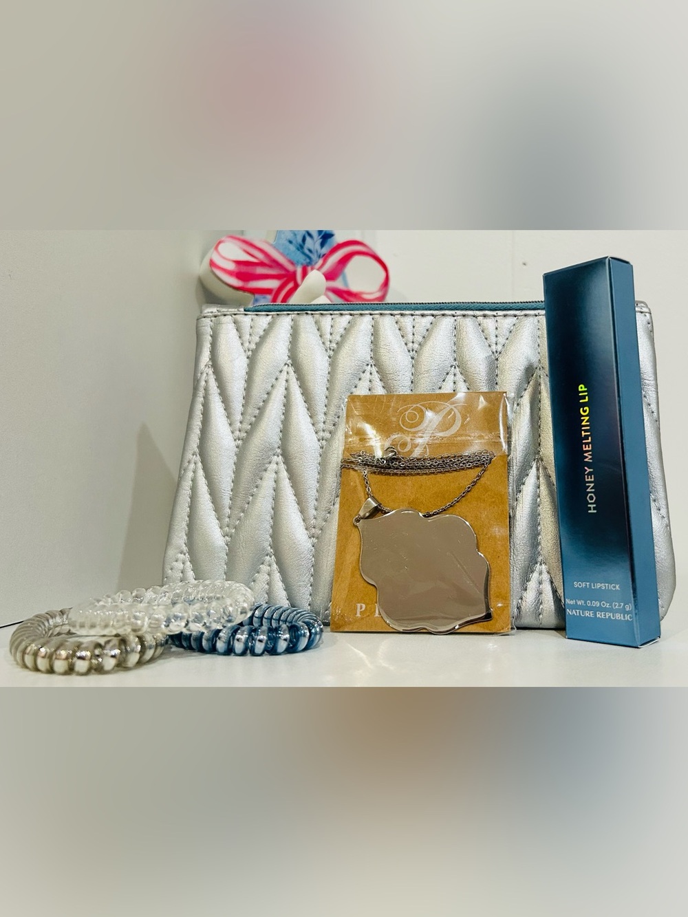 Silver Quilted Cosmetic Pouch with Mirror Pendant Necklace and Beauty Items